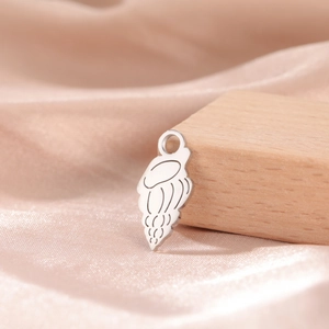 Macro shot of silver conch shell pendant on champagne silk with wooden background decor