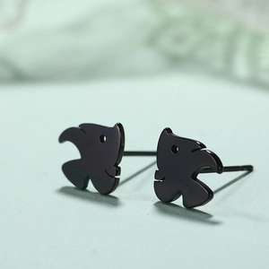 Makroaufnahme minimalistischer schwarzer Fisch-Ohrstecker aus Edelstahl auf grünem Grund