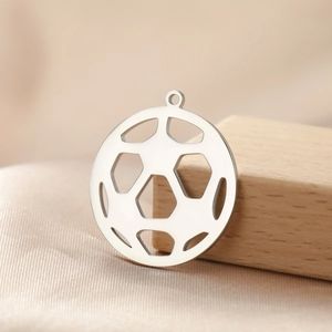 Detailed macro view of hollow out stainless steel soccer ball pendant on wooden block