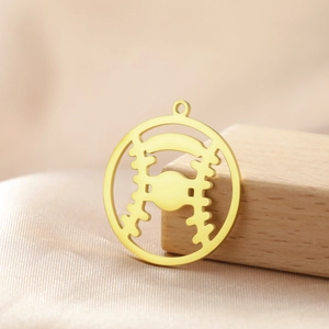 Detailed macro view of gold-plated hollow baseball pendant with stitch textures