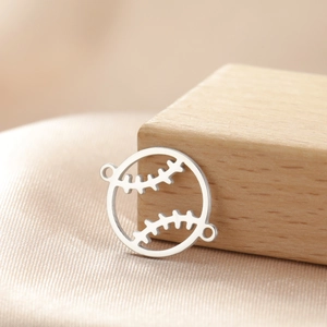 Macro shot of silver stainless steel baseball charm connector on silk background