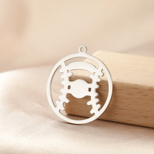 Detailed close-up of a stainless steel baseball pendant with hollow stitching design