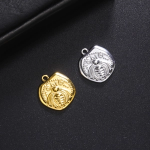Titanium steel coin pendants with bee embossed patterns in gold and silver finishes