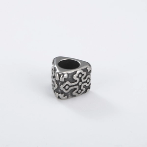 Macro detail of triangle vintage silver bead with embossed Celtic scroll patterns
