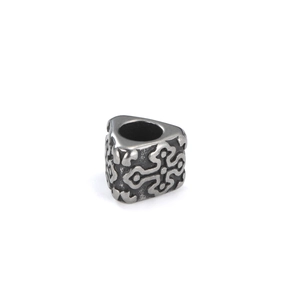 Macro detail of vintage silver triangle spacer bead with engraved Celtic patterns for DIY