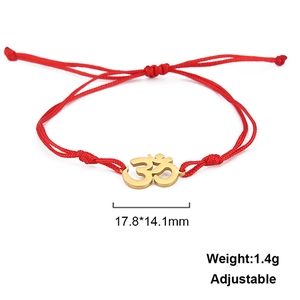 Detail of red braided cord bracelet with golden Om symbol charm and adjustable sliding knot