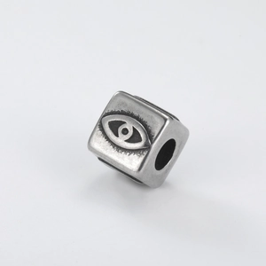 Gros plan d'une perle cube mauvais œil en argent antique pour la création de bijoux DIY