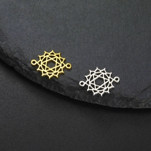 Macro detail of gold and silver hollow hexagram flower jewelry connectors on black rock