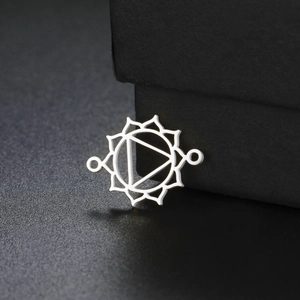 Macro view of silver chakra charm connector for jewelry making on black display