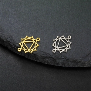 Gold and silver hollow chakra flower pendants on stone background for jewelry making