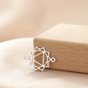 Polished silver hollow geometric flower pendant for necklaces and bracelets on silk background