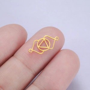 Vue macro d'un connecteur géométrique doré en triangle pour la création de bijoux DIY