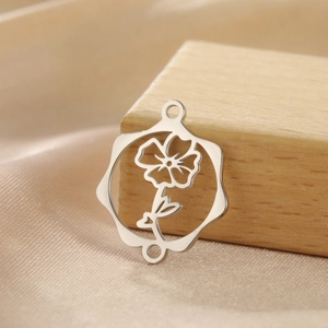 Détail macro du connecteur pendentif fleur argenté sur un élégant tissu en soie champagne