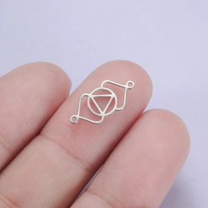 Détail macro d'un connecteur géométrique chakra argenté sur le bout d'un doigt