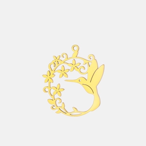 Gros plan d'un pendentif colibri en acier inoxydable doré avec couronne de fleurs