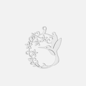 Détail macro du pendentif ajouré en acier inoxydable avec colibri et fleurs