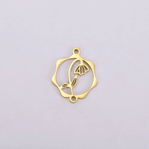 Détail macro du pendentif fleur doré ajouré avec deux anneaux de connexion pour la création