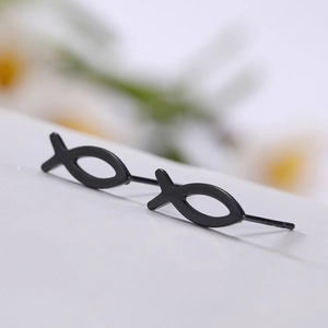 Macro view of minimalist black titanium steel fish earrings with hollow outline