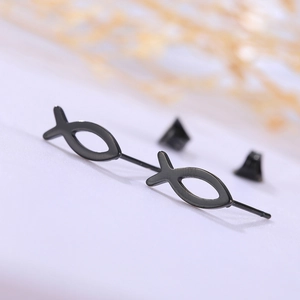 Macro view of minimalist black hollow fish stud earrings crafted from durable titanium steel