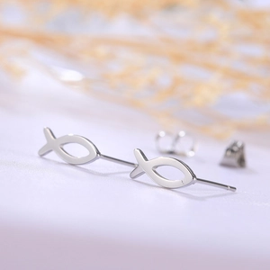 Macro shot of polished hollow fish-shaped titanium steel stud earrings with butterfly backings