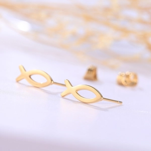 Macro shot of minimalist gold fish studs with smooth geometric lines and butterfly backs