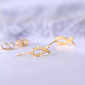 Detailed macro view of golden fish-shaped titanium steel stud earring with a glossy finish