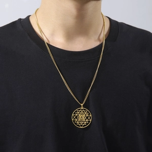 Gouden Sri Yantra hanger ketting op een zwart shirt voor een minimalistische stijl