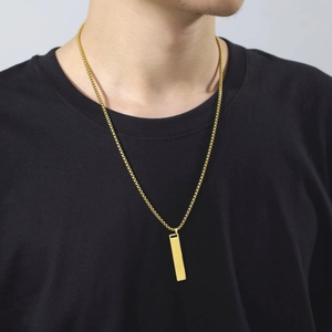 Colgante de barra rectangular minimalista dorado en cadena de caja con camiseta negra