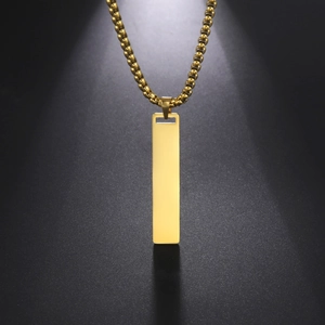 Collar de cadena box dorada con colgante de barra rectangular pulida sobre fondo negro