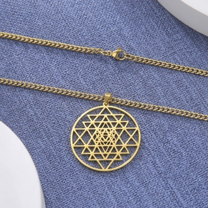 Detail van gouden titanium stalen ketting met holle ronde heilige geometrie hanger