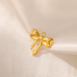 Detailed close-up of matte gold bow pendant on silk, DIY jewelry accessory