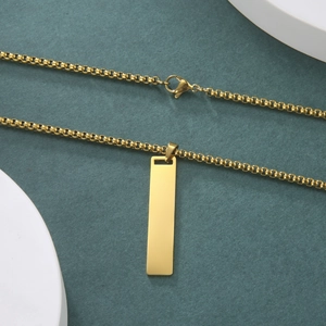 Detalle del colgante rectangular dorado con cadena de caja en soporte