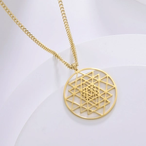 Macro-opname van de gouden Sri Yantra-hanger van roestvrij staal op een wit voetstuk