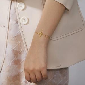 Bracelet élégant en acier doré avec nœud celtique porté au poignet d'une femme