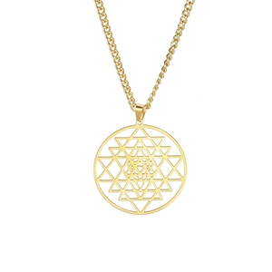 Detail van de gouden geometrische Sri Yantra cirkelhanger aan een klassieke schakelketting