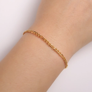 Dettaglio macro del bracciale Figaro in acciaio inossidabile placcato oro 18K al polso