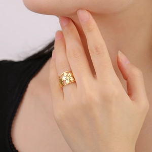 Dettagliato primo piano di un anello a fiore di ciliegio traforato d'oro al dito