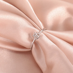 Minimalist stainless steel ring with double female symbols on pink satin background