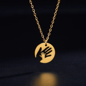 Gold stainless steel necklace with cutout circular pendant showing parent and child hands