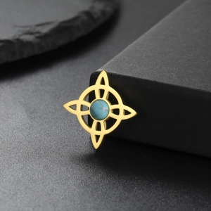 Detalle de colgante nudo de bruja dorado con incrustación de turquesa en estuche negro