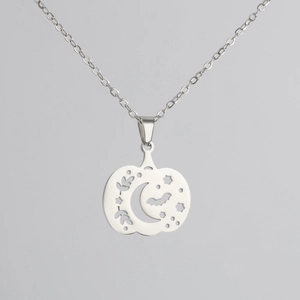 Close-up of hollow pumpkin pendant with moon and bat details on a silver chain
