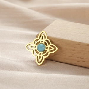 Detalle de colgante de nudo celta dorado con una piedra preciosa azul incrustada