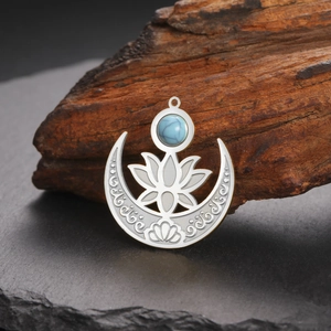 Détail macro du pendentif lotus argenté avec pierre turquoise sur fond de bois naturel