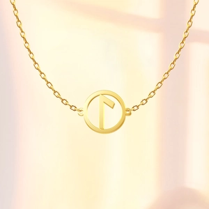 Macro shot of a gold Viking Rune pendant on an O-chain with artistic shadow lighting