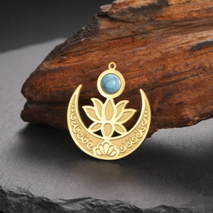 Pendentif lotus lune doré 18 carats avec pierre saphir bleue sur un fond en pierre noire