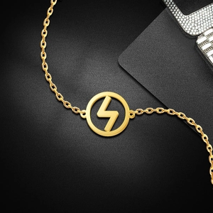 Close-up of a gold lightning bolt pendant on an O-chain with polished steel finish