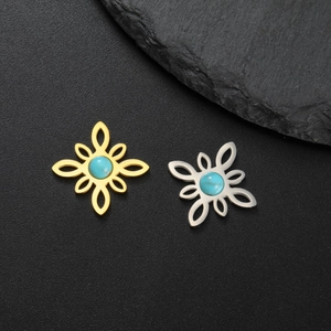 Detalle de colgantes florales con piedras turquesas en acabados oro y plata