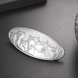 Close-up of vintage silver alloy hair clip with detailed cat relief and embossed pattern