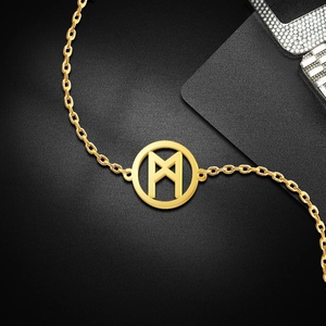 Macro detail of 18K gold Viking Rune pendant on O-chain necklace over black background
