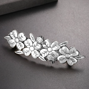 Detail of silver vintage flower hair clip with ladybug design and antique finish